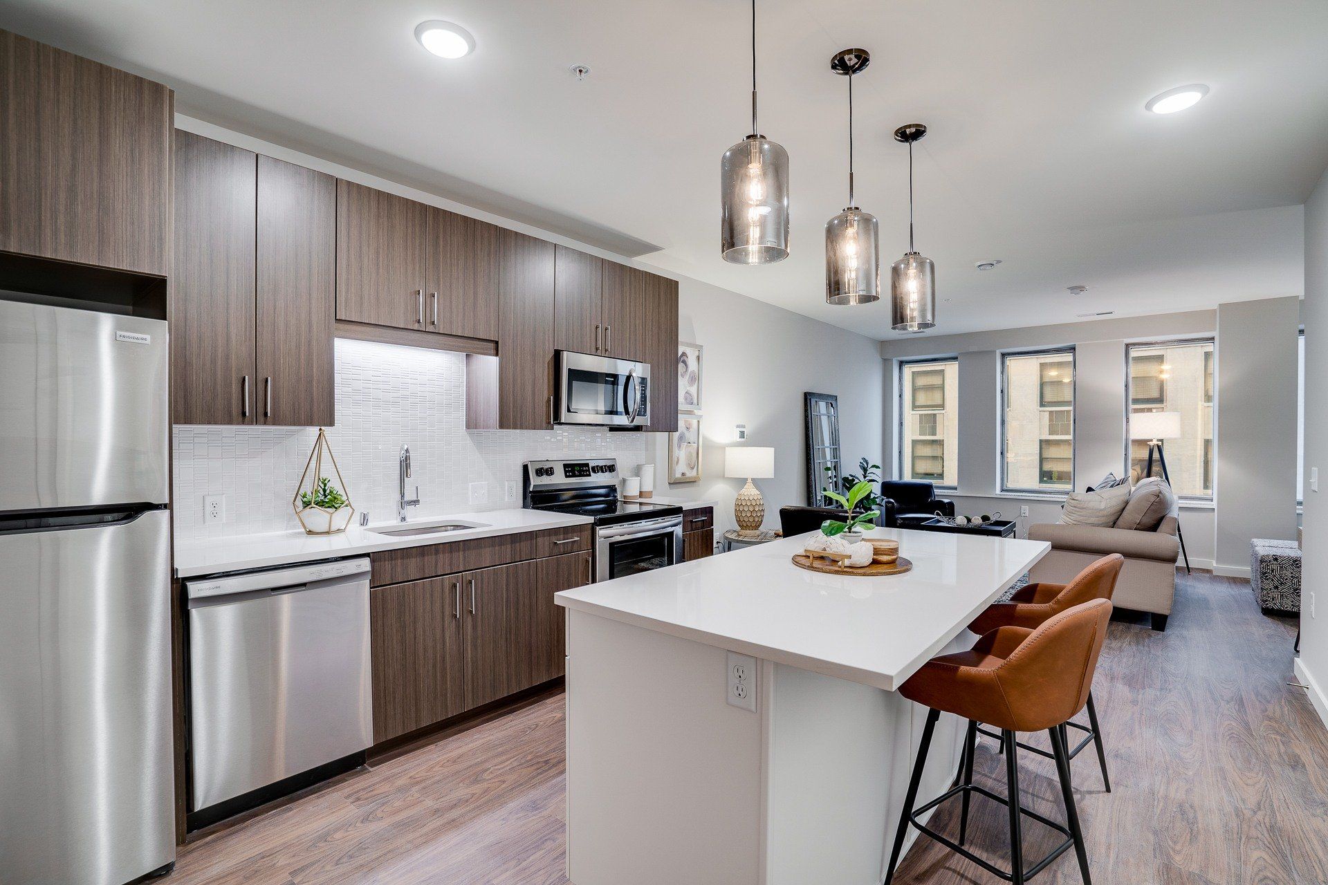 Open-concept kitchen with wood cabinets, stainless steel appliances, and a white island.