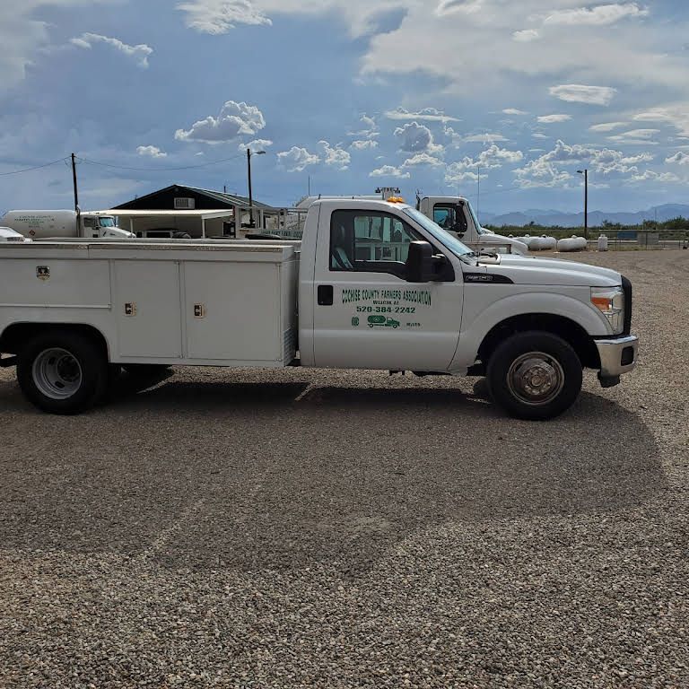 a white utility truck is parked in a gravel lot