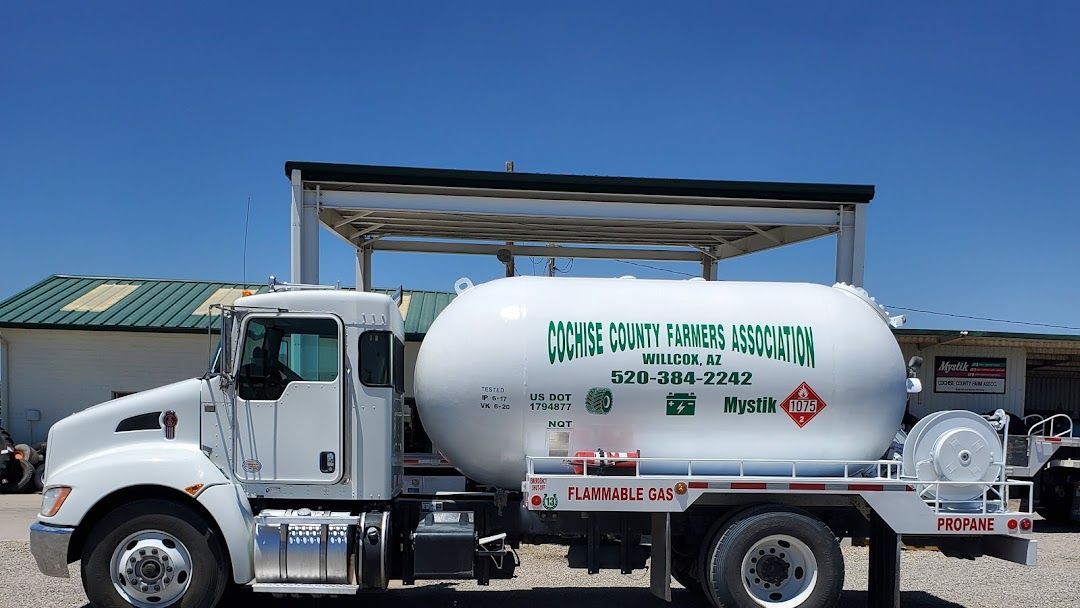 a white tanker truck is parked in front of a building