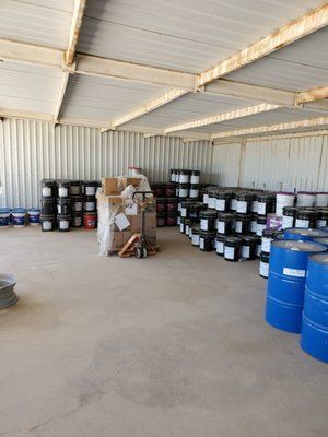a large warehouse filled with lots of barrels and boxes .