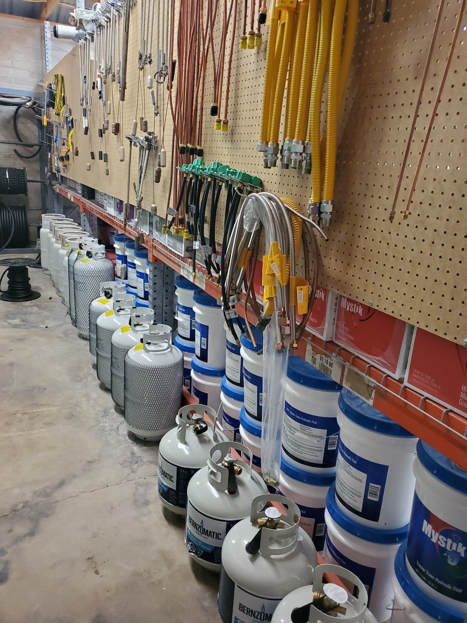 a warehouse filled with lots of propane tanks and tools .