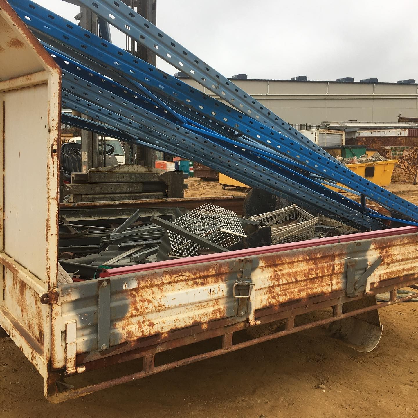 A Rusty Car is Sitting in the Dirt Next to a White Car — Anderson Waste Services in Mittagong, NSW