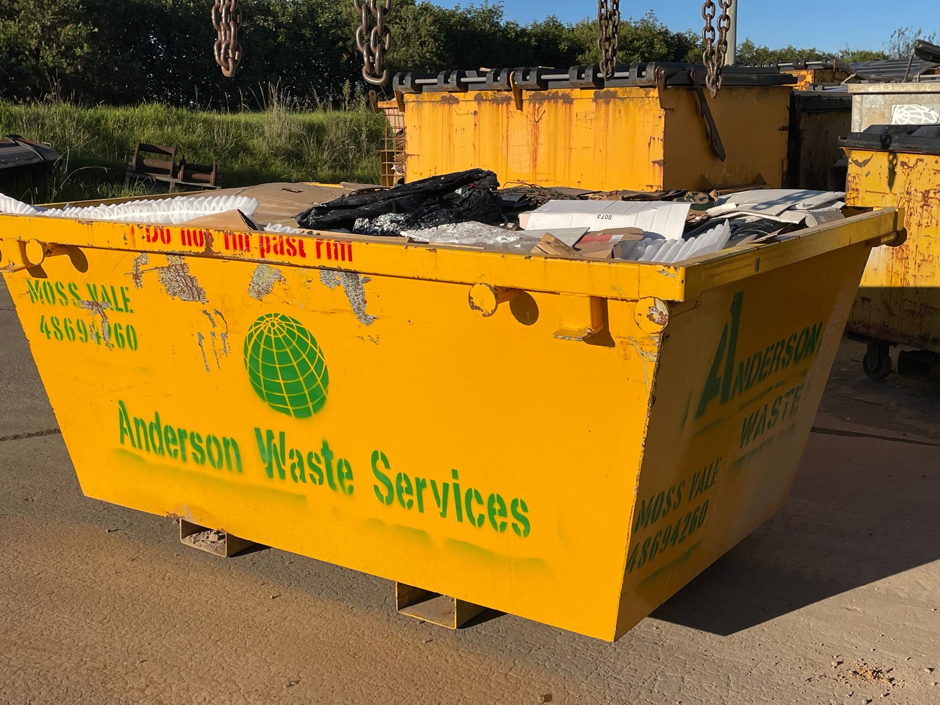 A Yellow Dumpster With Rubbish Inside— Anderson Waste Services in Mittagong, NSW