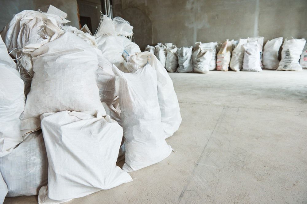 A Bunch of Bags Are Stacked on Top of Each Other in a Room — Anderson Waste Services in Picton, NSW