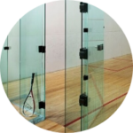 A squash racket is sitting on a wooden court in a circle.