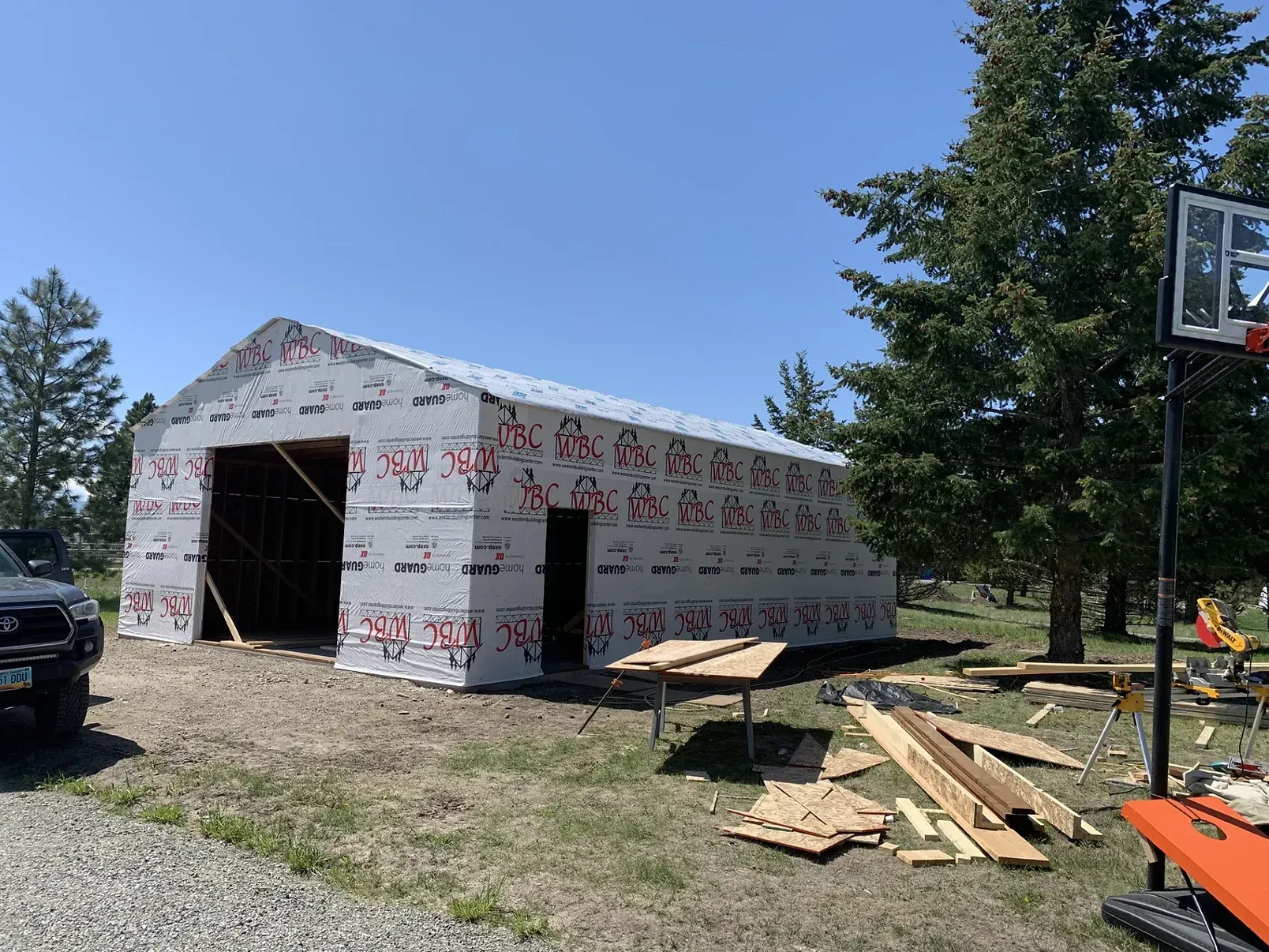 A basketball hoop is sitting in front of a building under construction.