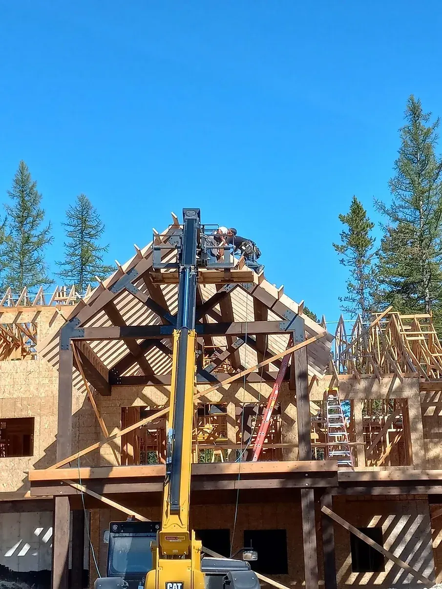 A large house is being built with a crane on top of it.