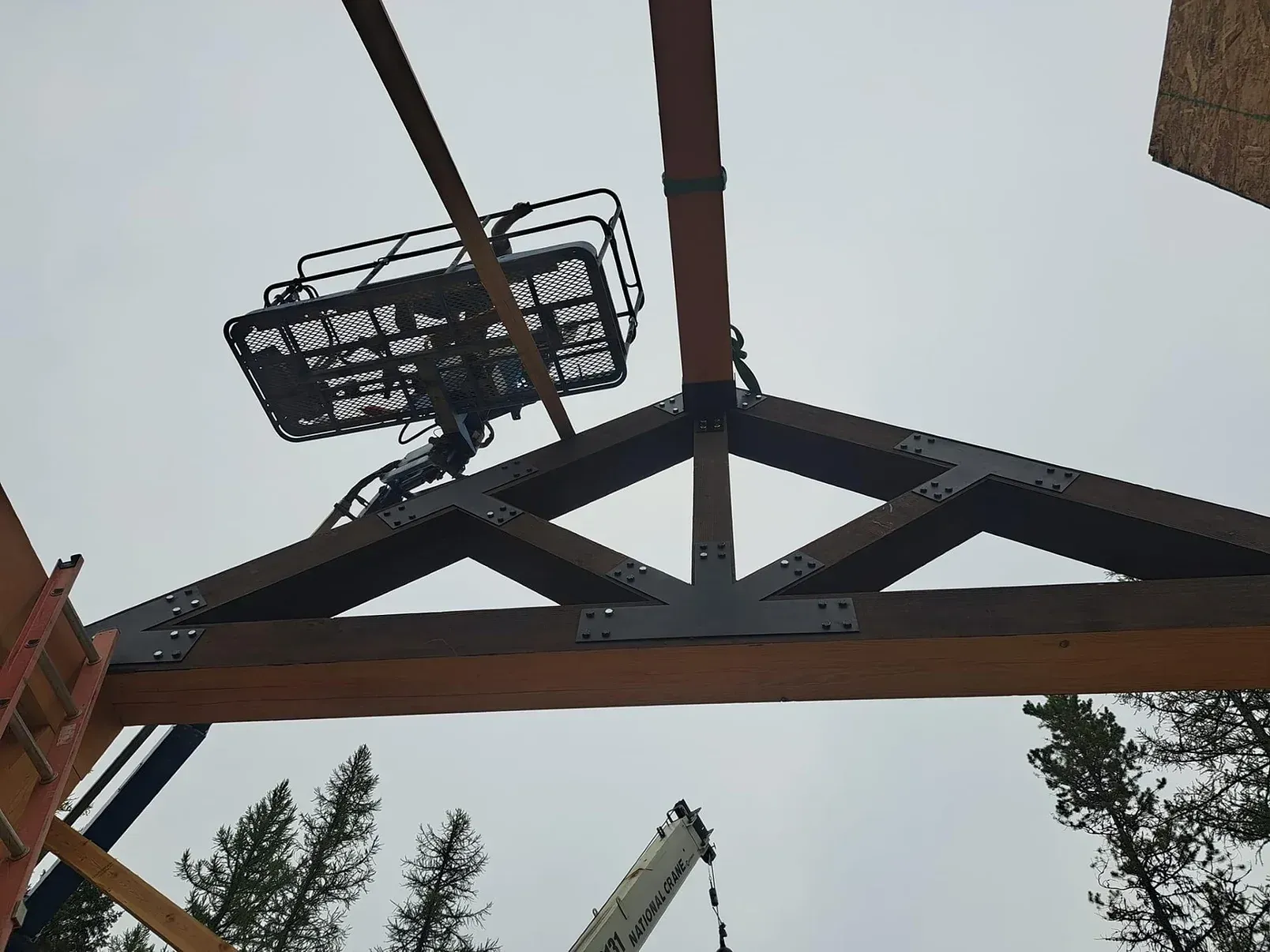 A crane is lifting a wooden structure in the air.