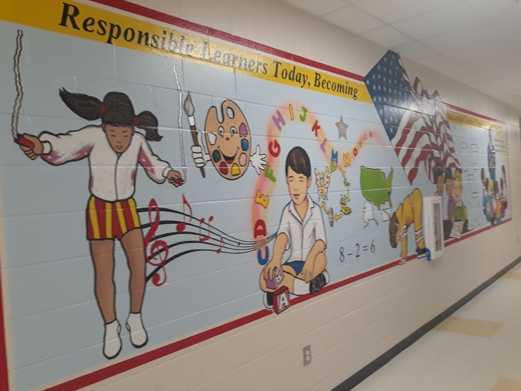 Mural in a hall way depicting  children playing and learning and an american flag