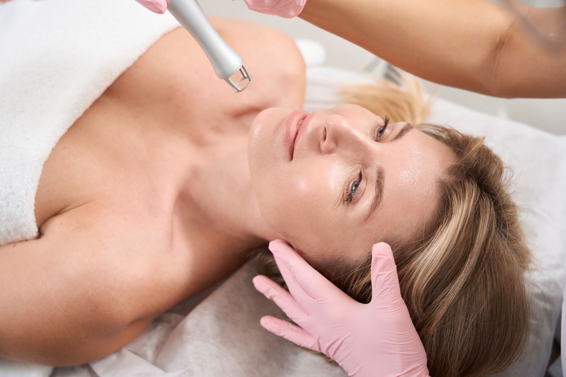 A woman is getting a laser treatment on her face.