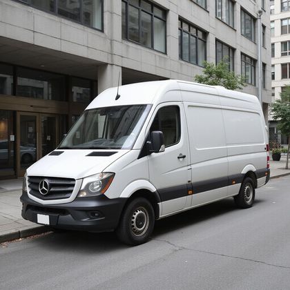 White Mercedes-Benz cargo van parked on city street in front of a modern building.