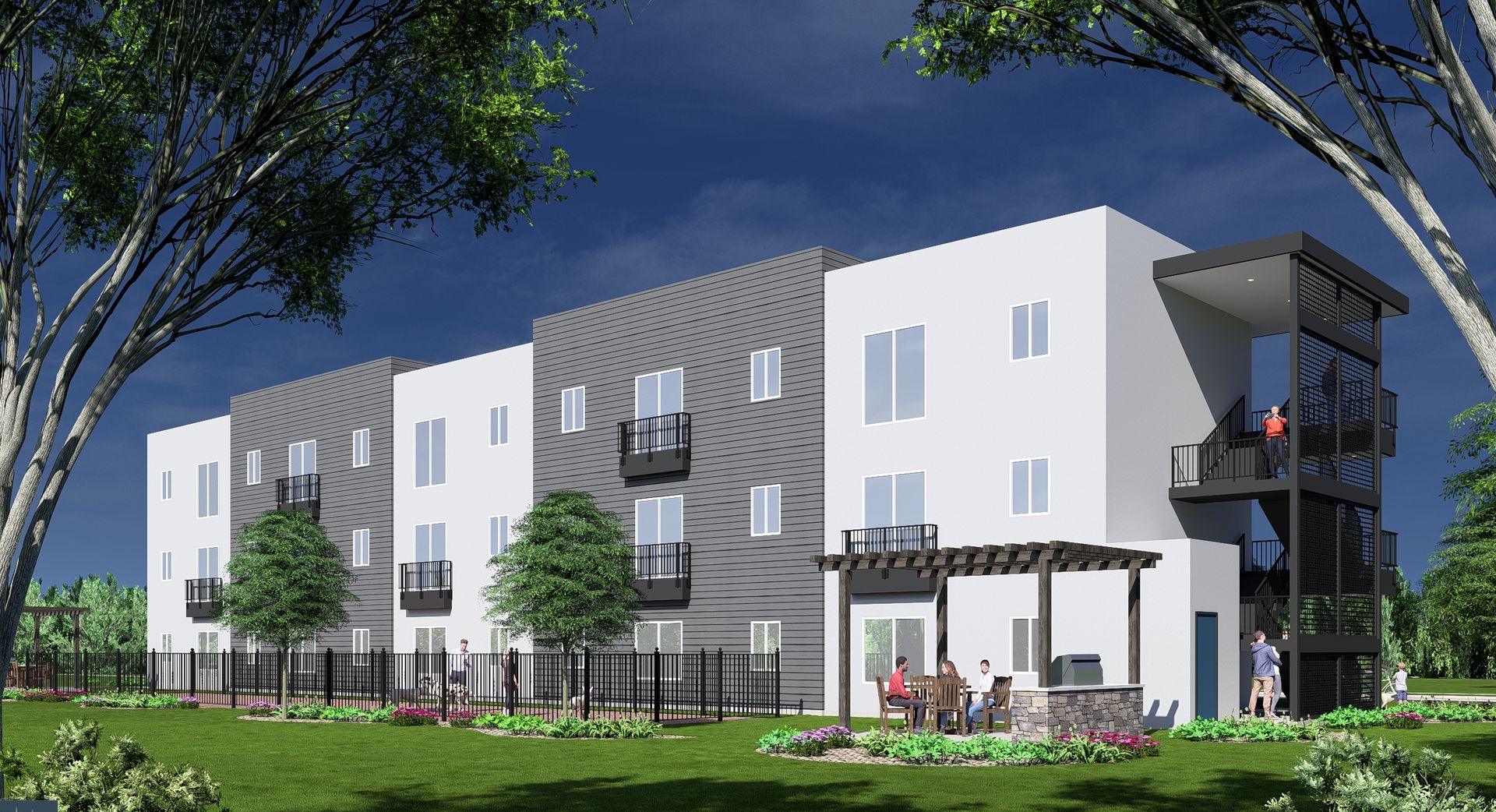 Modern apartment building with white and gray exterior, balconies, and a patio with people.