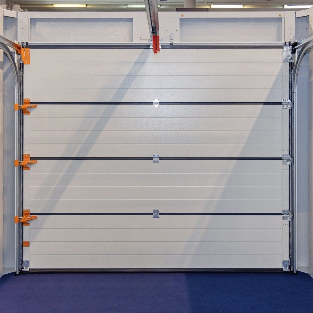 White sectional garage door with horizontal supports and orange brackets.