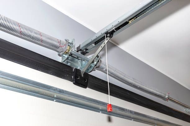 Garage door spring and track mechanism, mounted on a ceiling.
