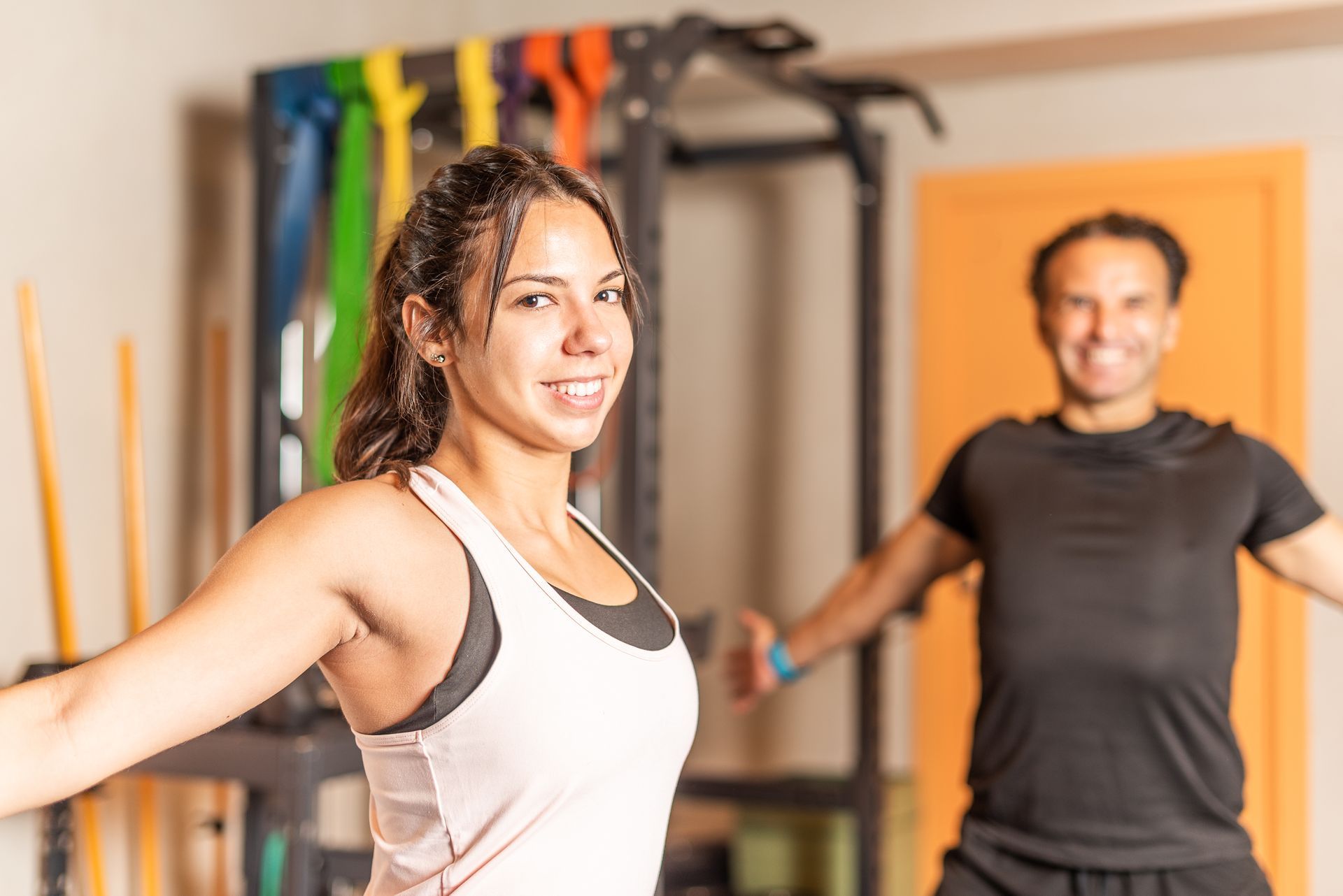 A man and a woman are doing exercises in a gym.