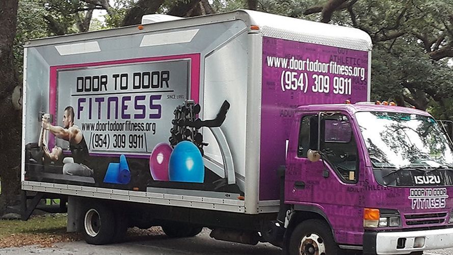 A purple truck that says door to door fitness