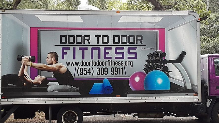A truck that says door to door fitness on the side