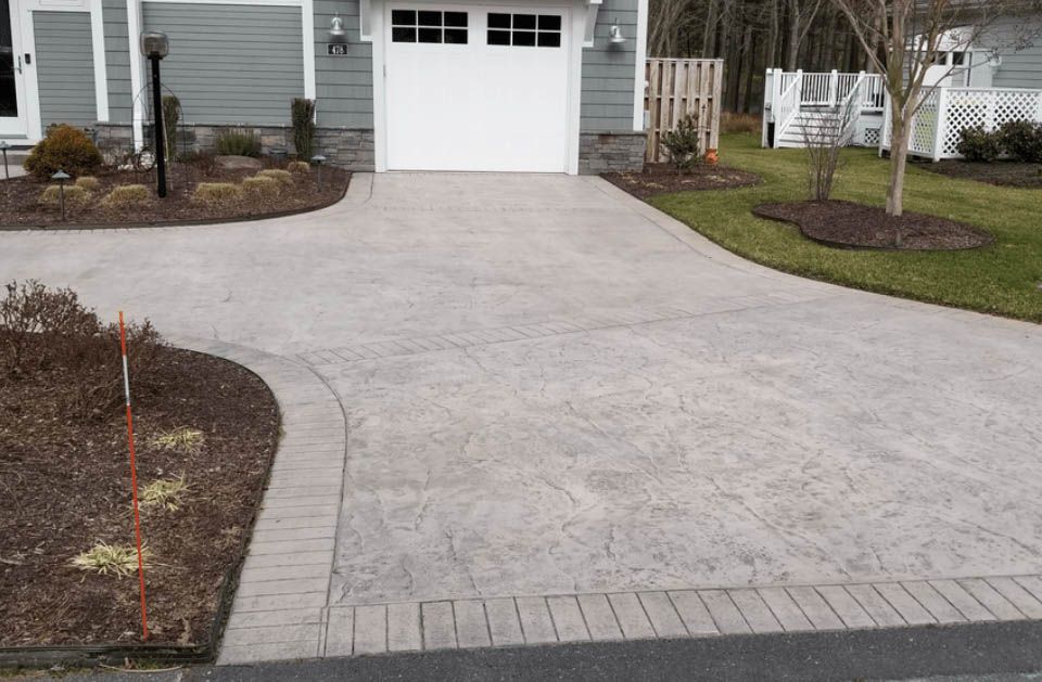 A driveway leading to a house with a white garage door
