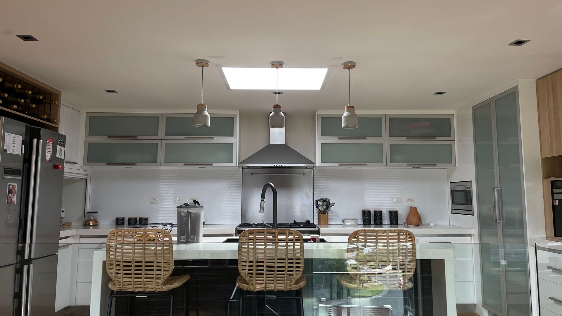 A kitchen with stainless steel appliances and wicker chairs