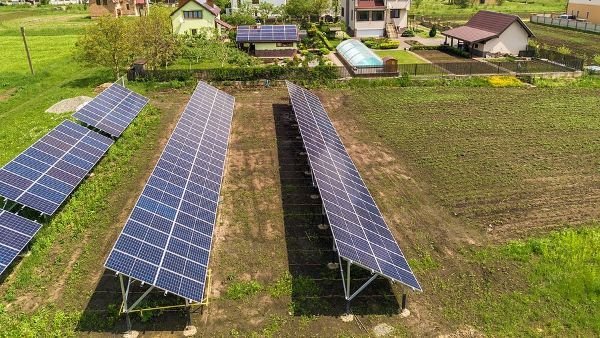 An aerial view of a row of solar panels in a field.