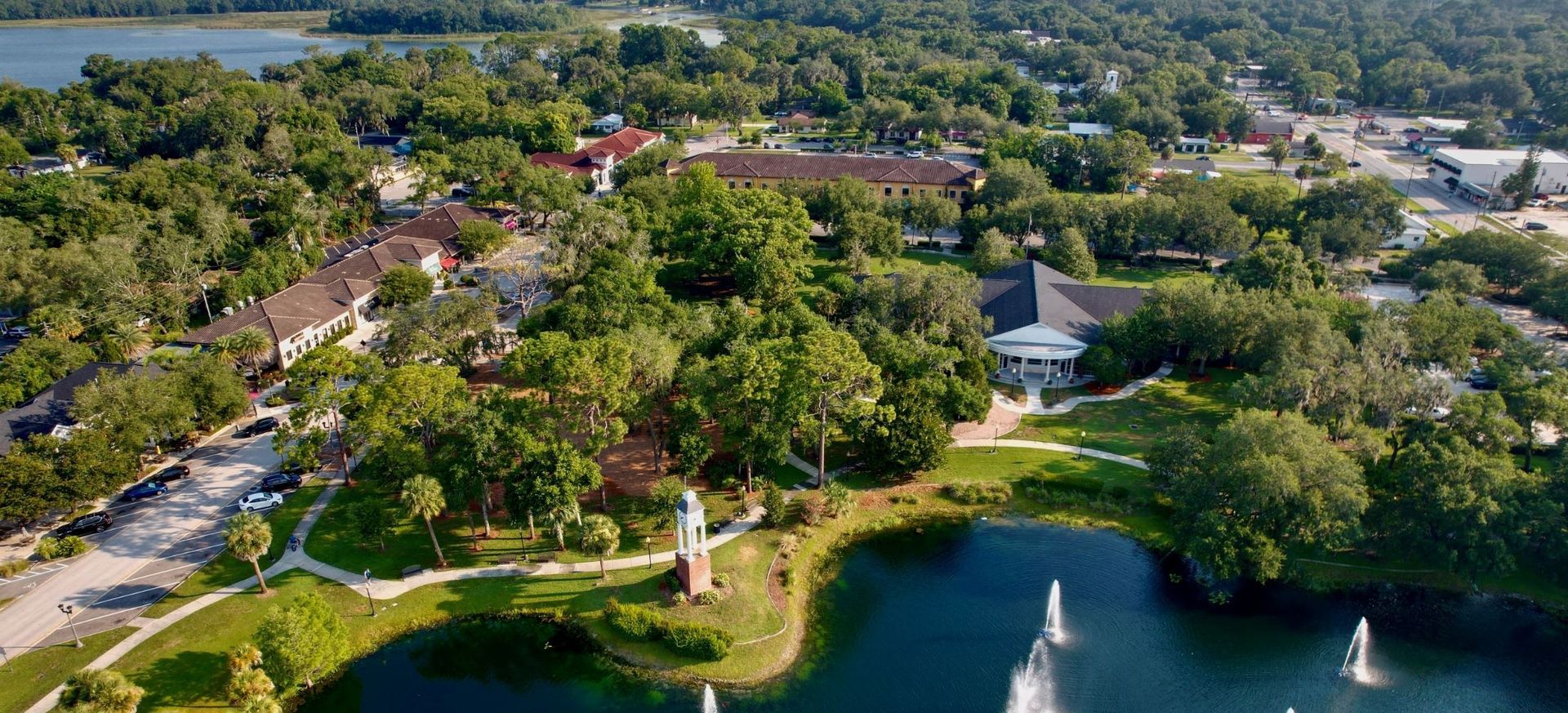 An aerial view of a lake surrounded by trees and fountains.