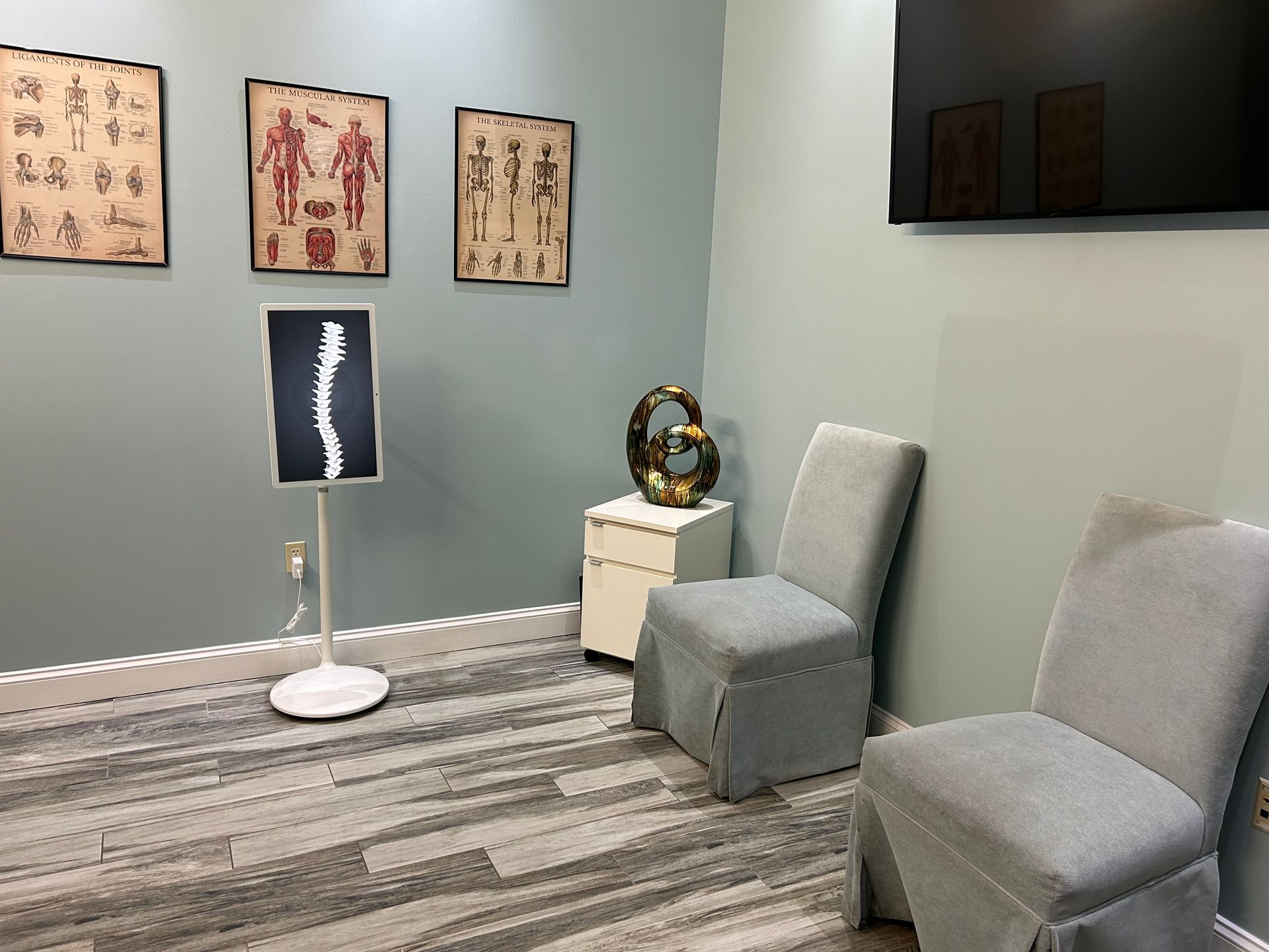 A waiting room with two chairs and a flat screen tv.