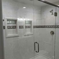 A shower stall with a glass door and a shower head.