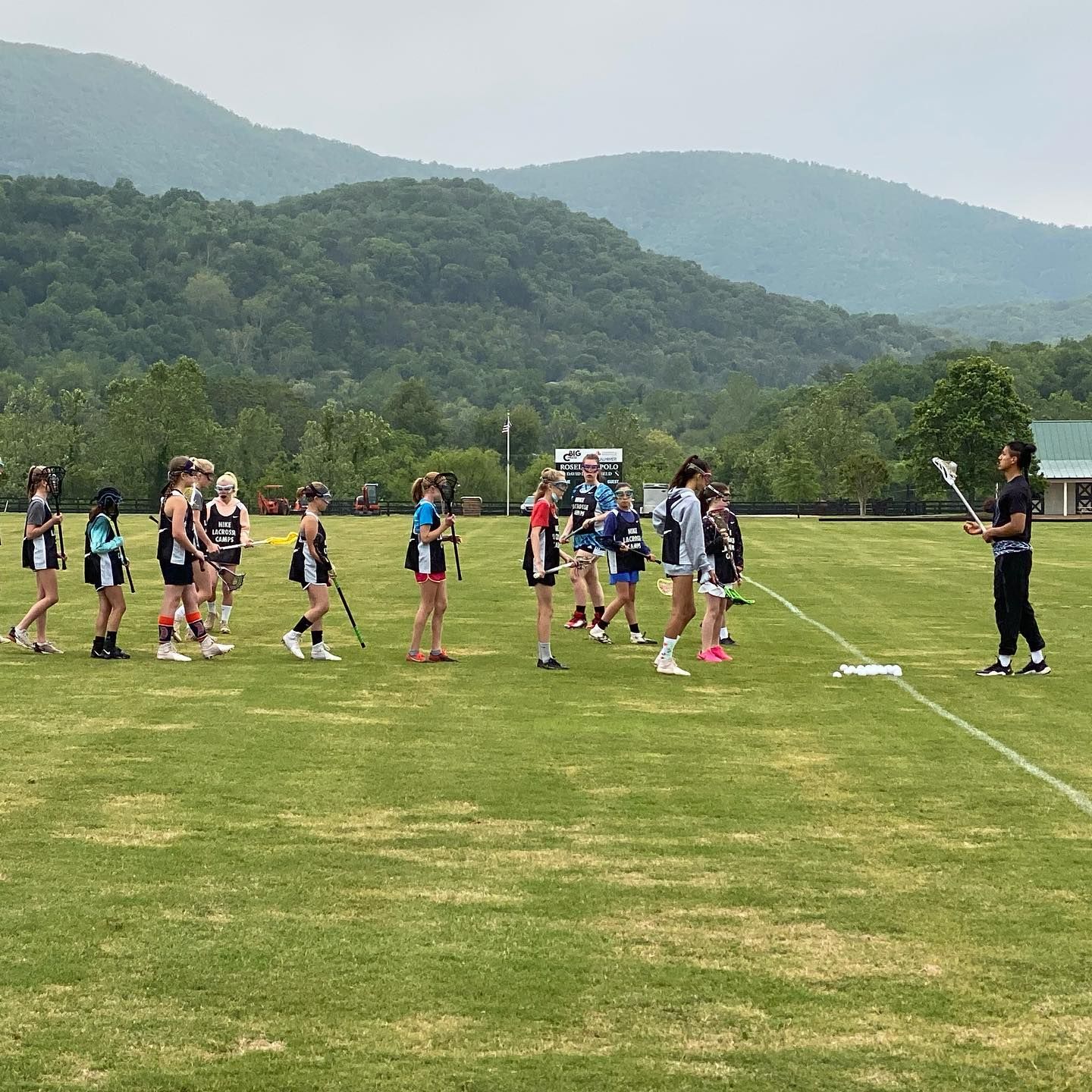 CAV Lax Elite players huddled on field during practice in the Charlottesville mountains