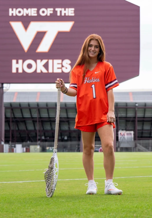 CAV Lax Elite player commits to Virginia Tech Women's Lacrosse, pictured in Hokies uniform in stadium