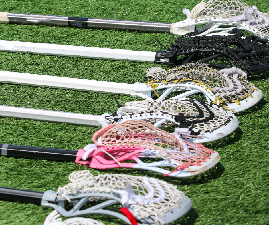 picture of lacrosse sticks on the ground in a row