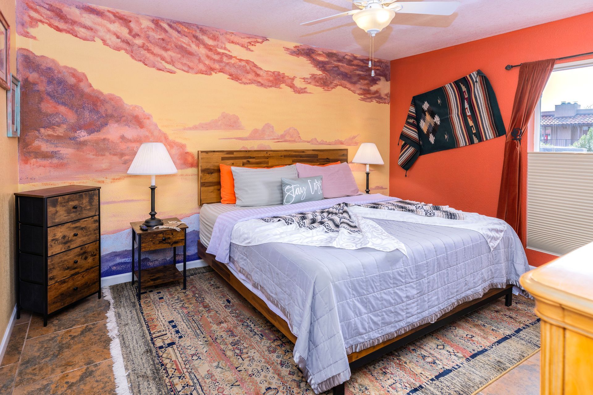 A bedroom with a large bed and a painting on the wall.