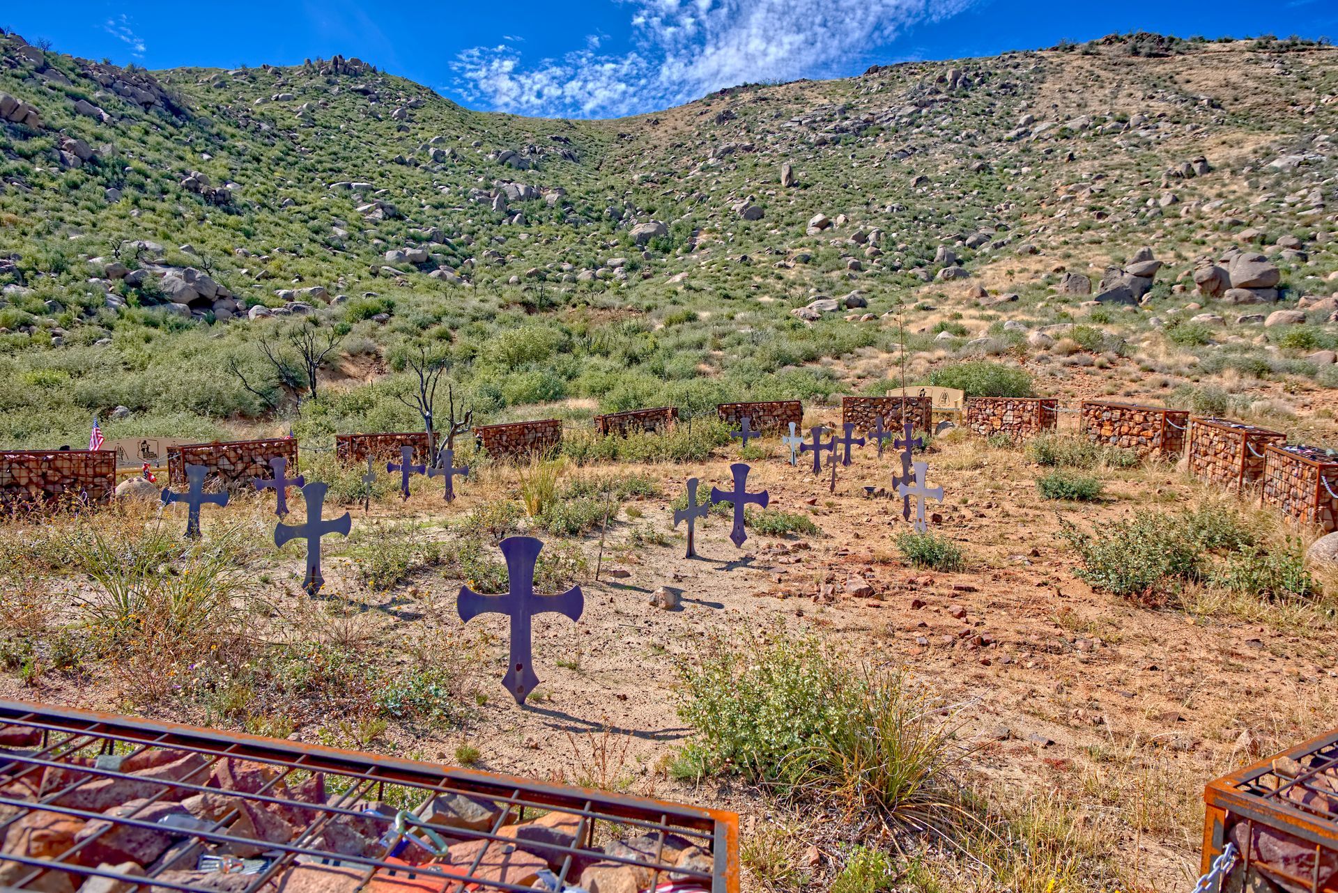 A cemetery with a lot of crosses in the middle of a desert.