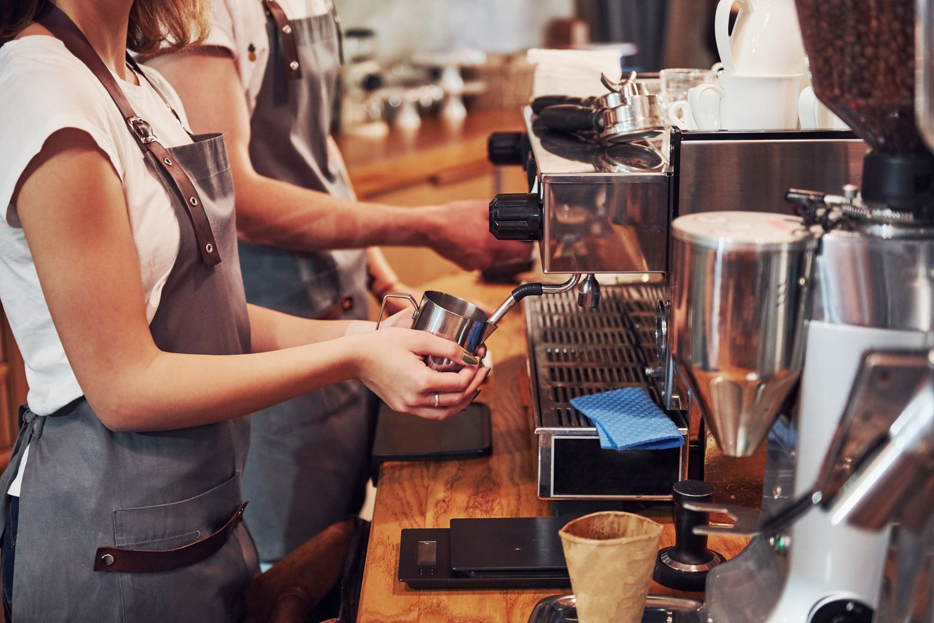 A group of people are working in a coffee shop making coffee.