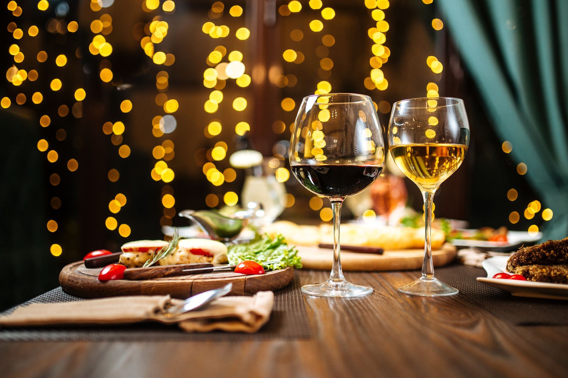 A wooden table topped with plates of food and wine glasses.