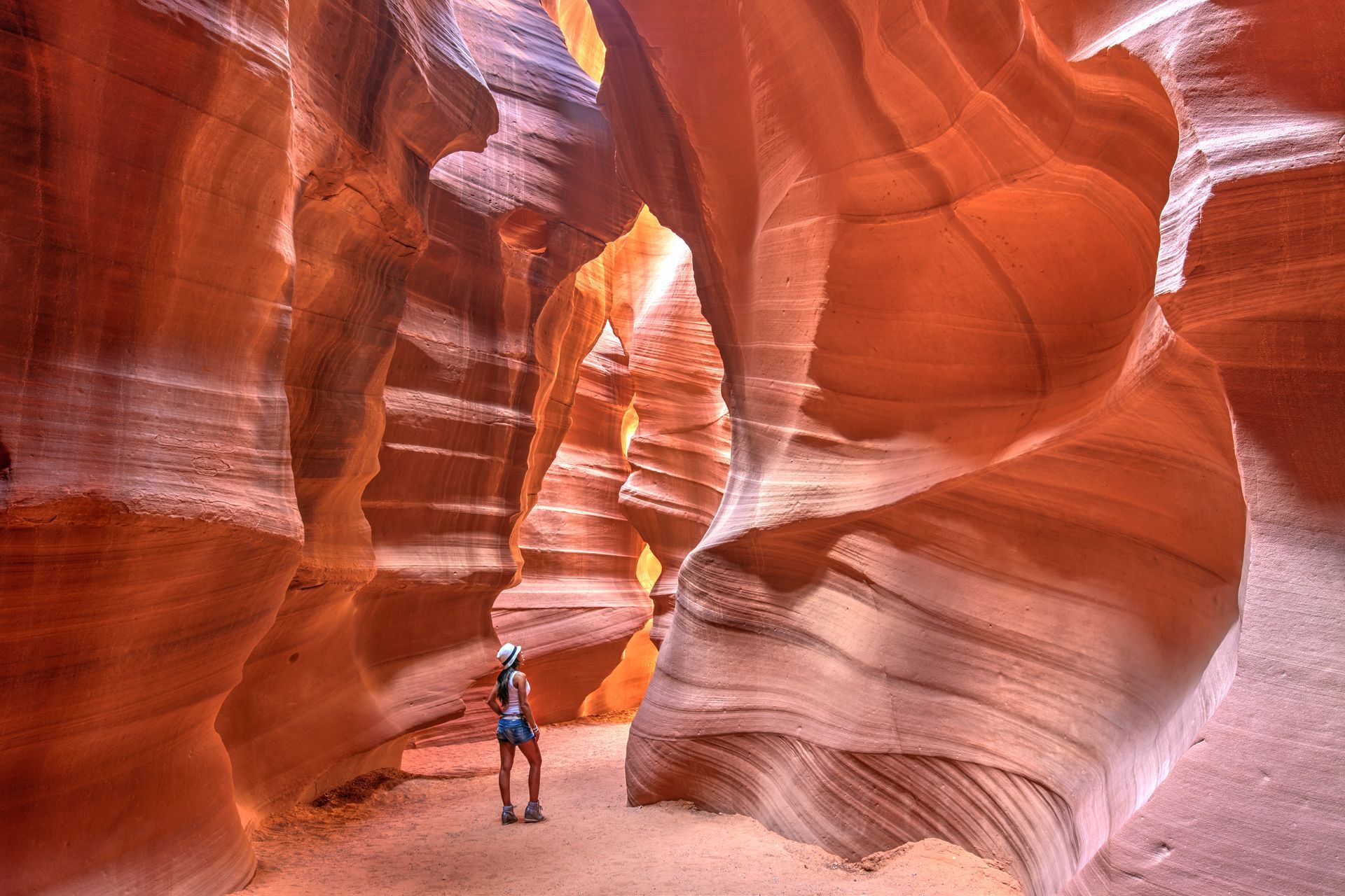 A woman is standing in the middle of a canyon.