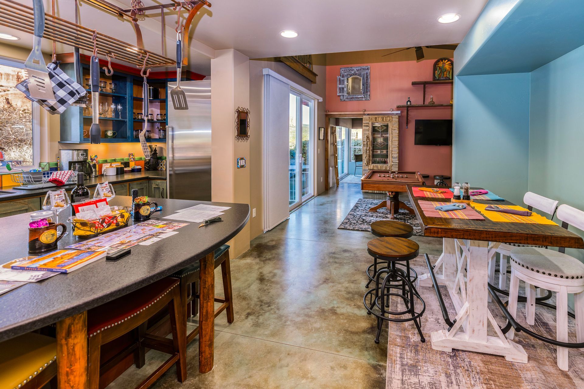 A kitchen with a large table and stools in it.