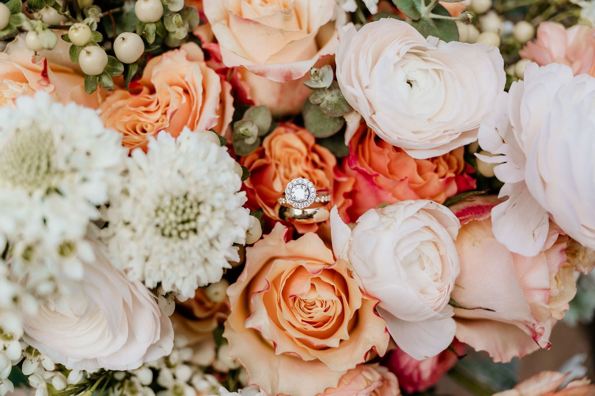 A wedding ring is sitting on top of a bouquet of flowers.