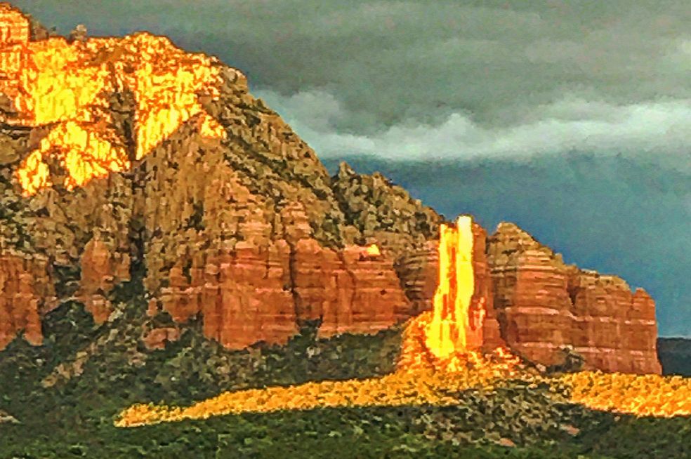 A mountain with a cloudy sky in the background