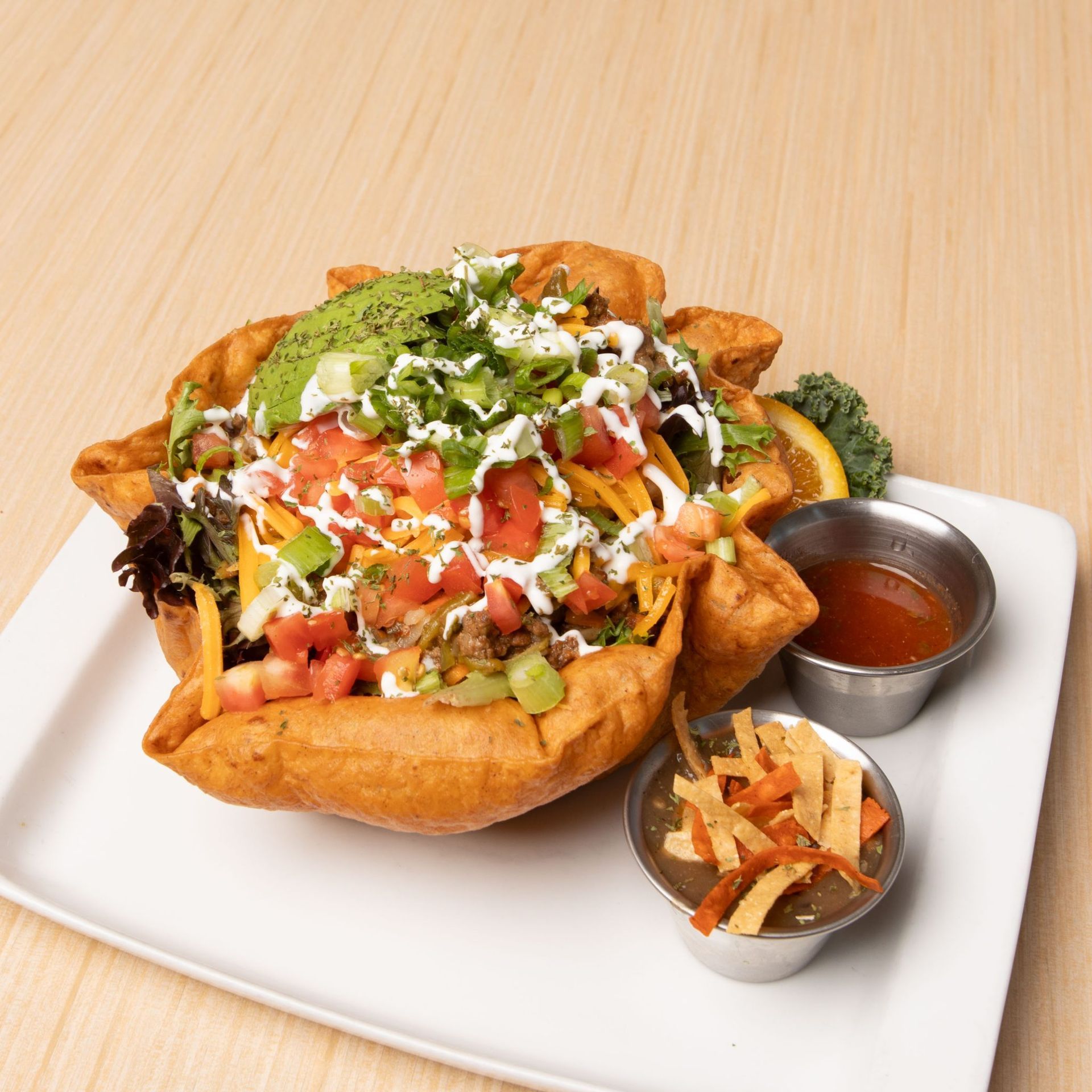 A white bowl filled with fried seafood and french fries on a table.