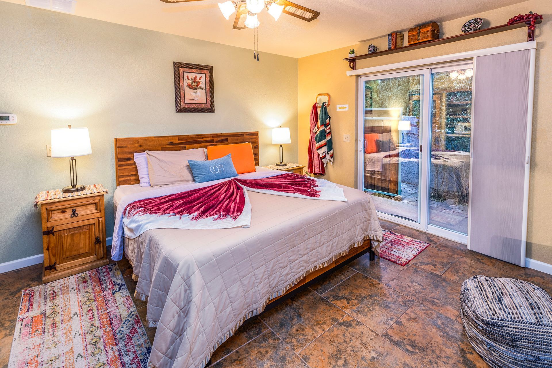 A bedroom with a king size bed and a sliding glass door.