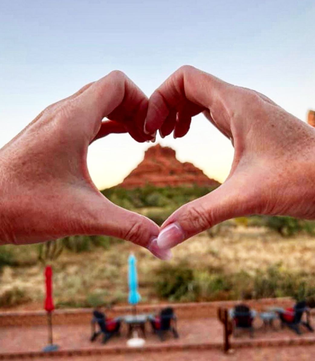 A person is making a heart shape with their hands