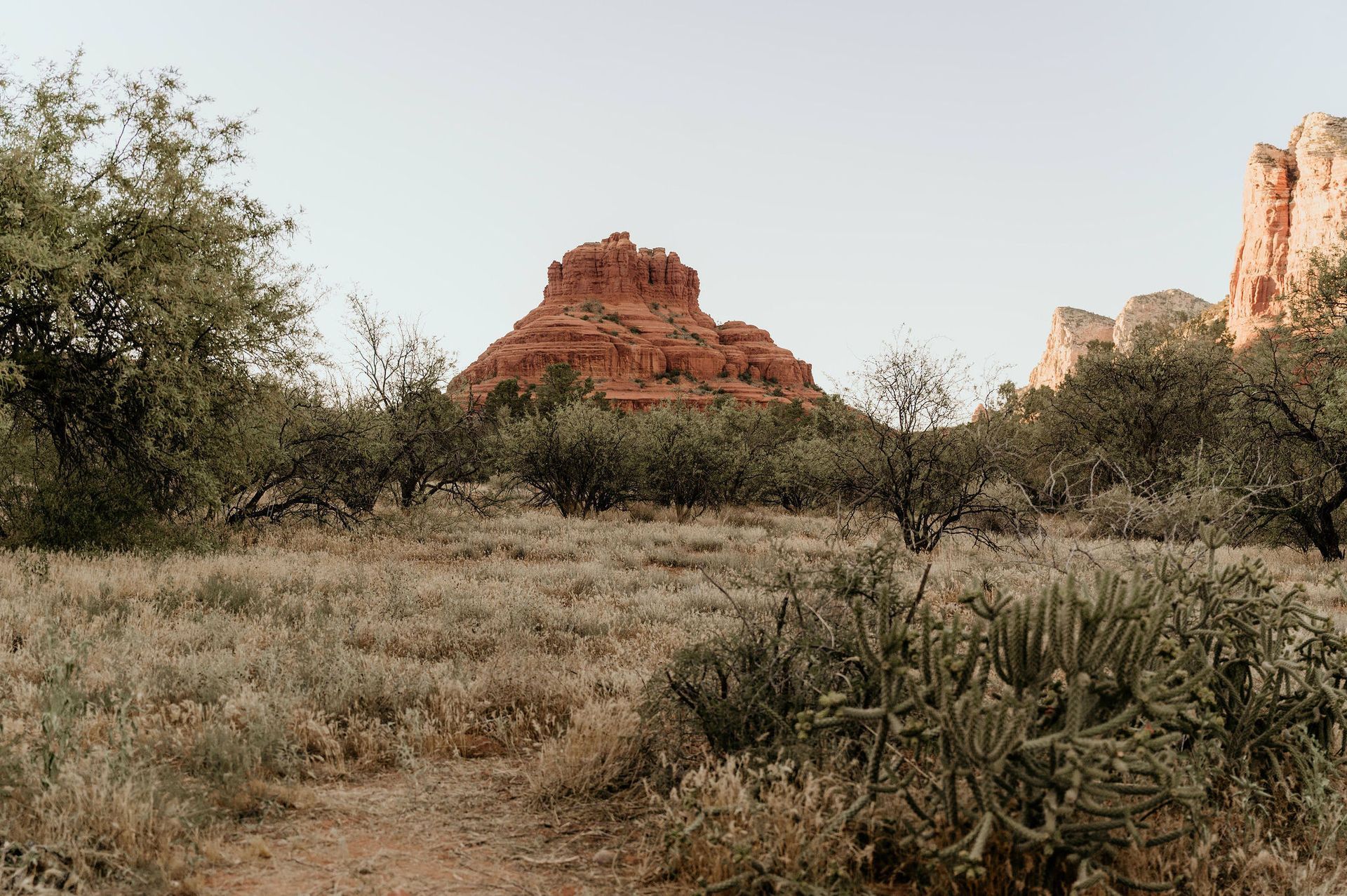 A desert landscape with a mountain in the background and a path in the foreground.