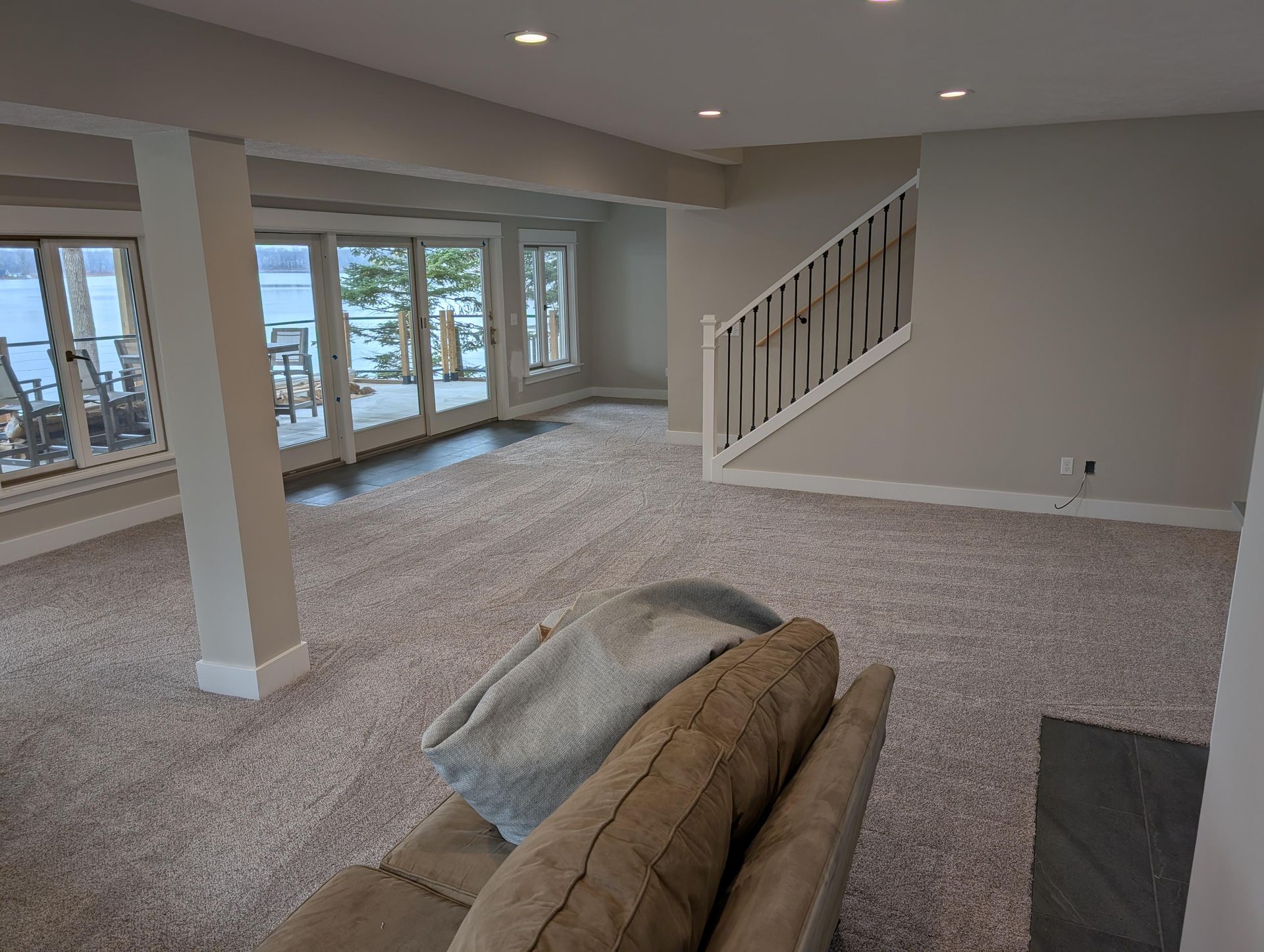 A living room with a couch , chair , and stairs.