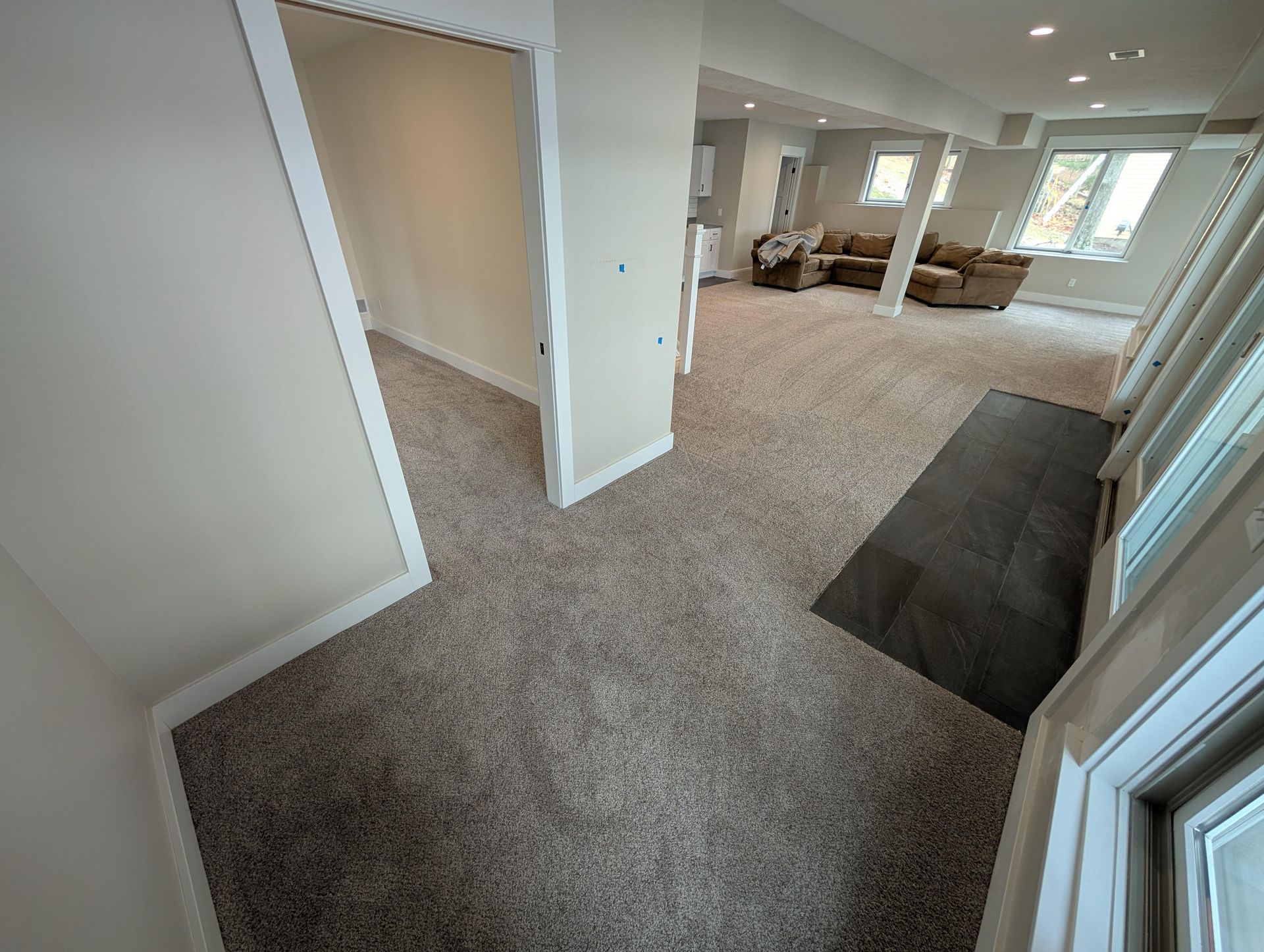 A living room with a lot of furniture and a carpeted floor.