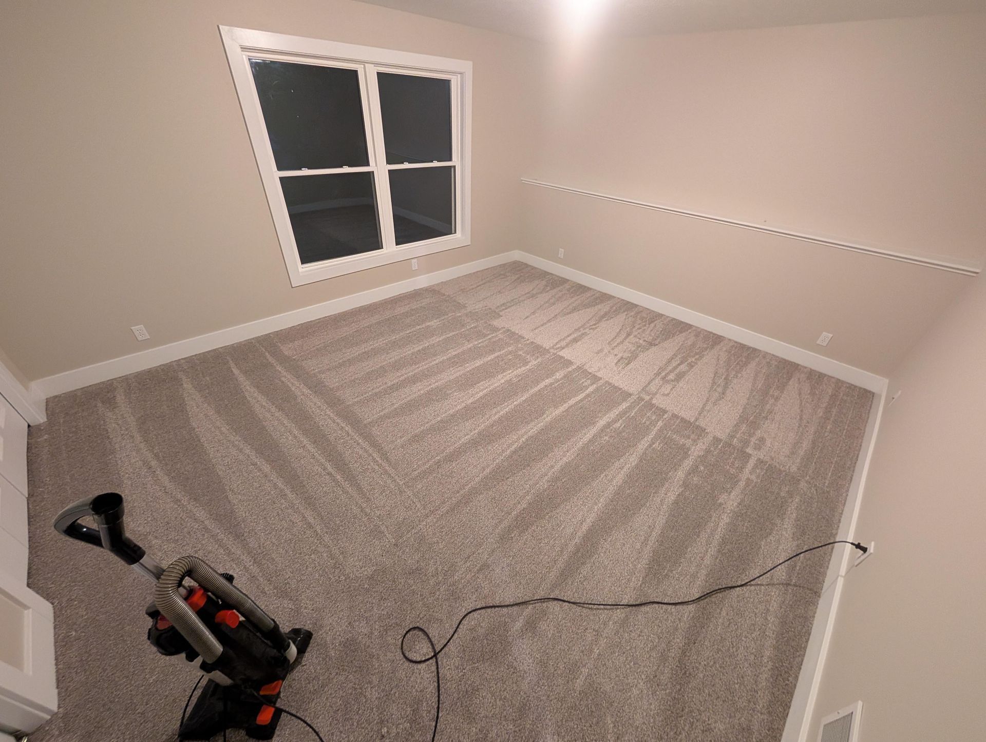 There is a vacuum cleaner in the middle of the room.