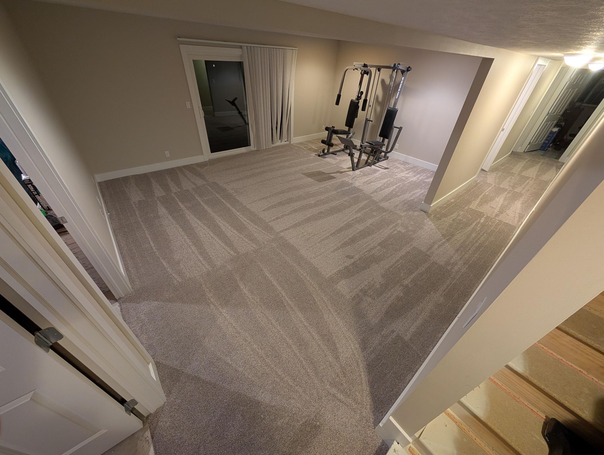 A room with a carpeted floor and a gym equipment in it