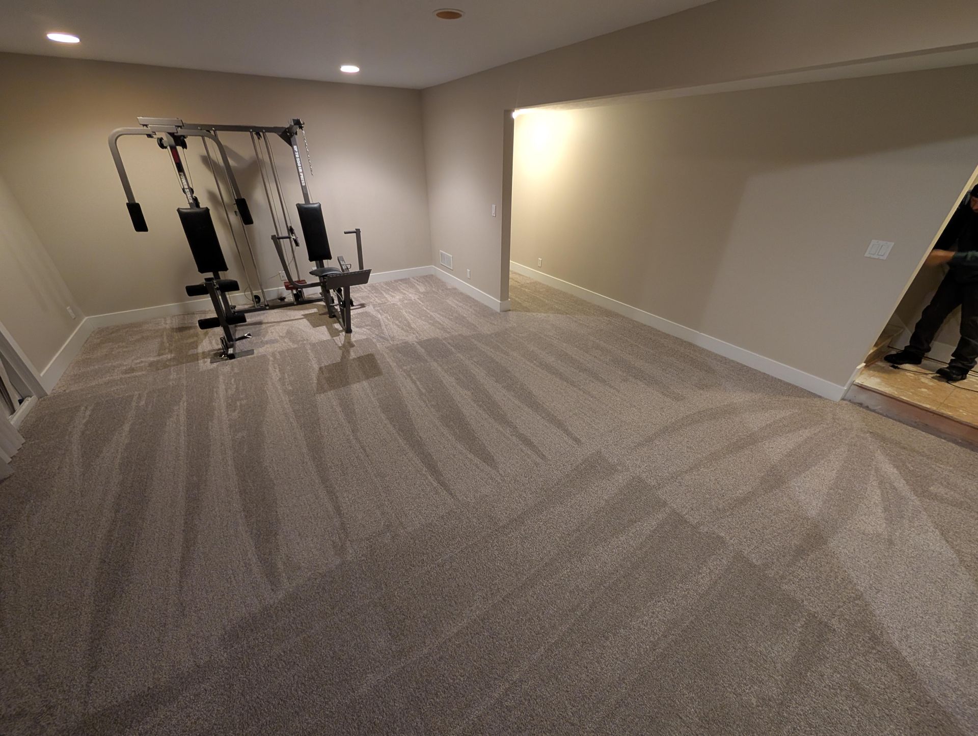 A man is standing in a room with a gym equipment in it.