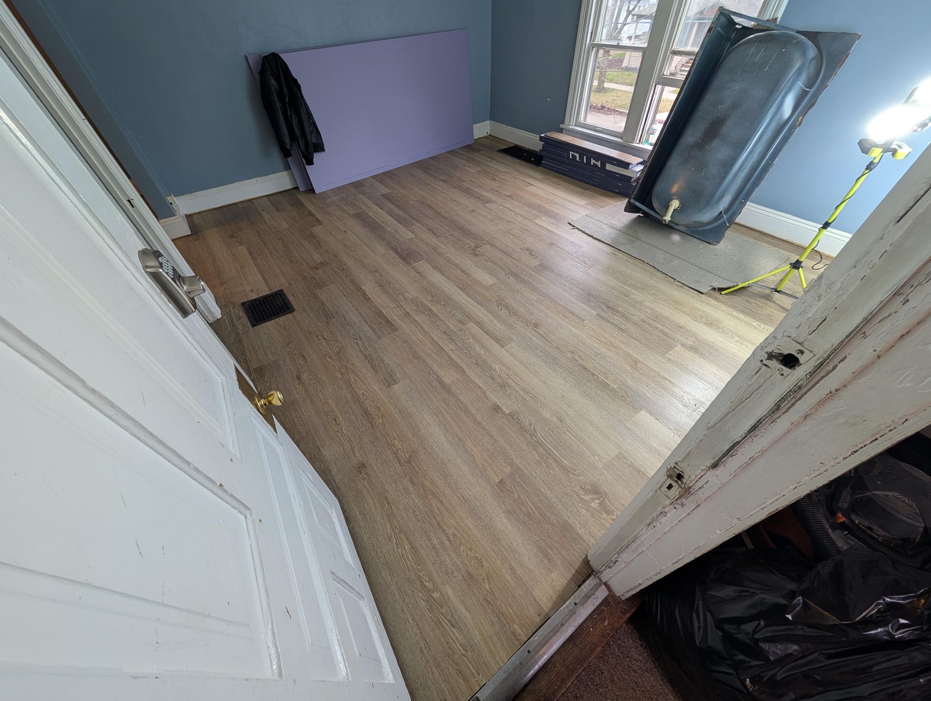 A room with a wooden floor and a window.