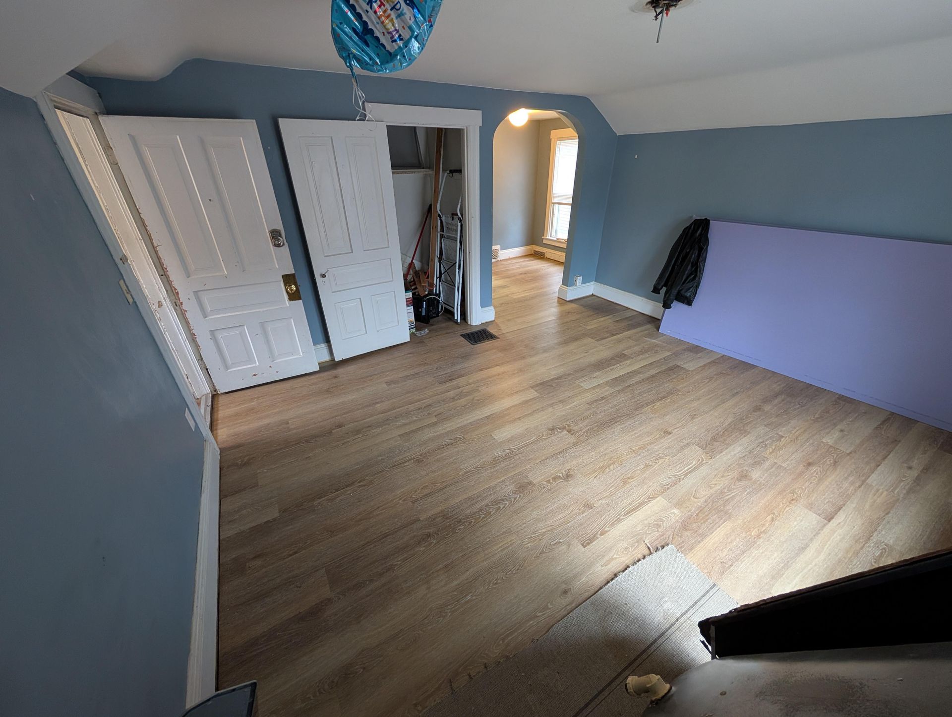 A room with a wooden floor and blue walls.