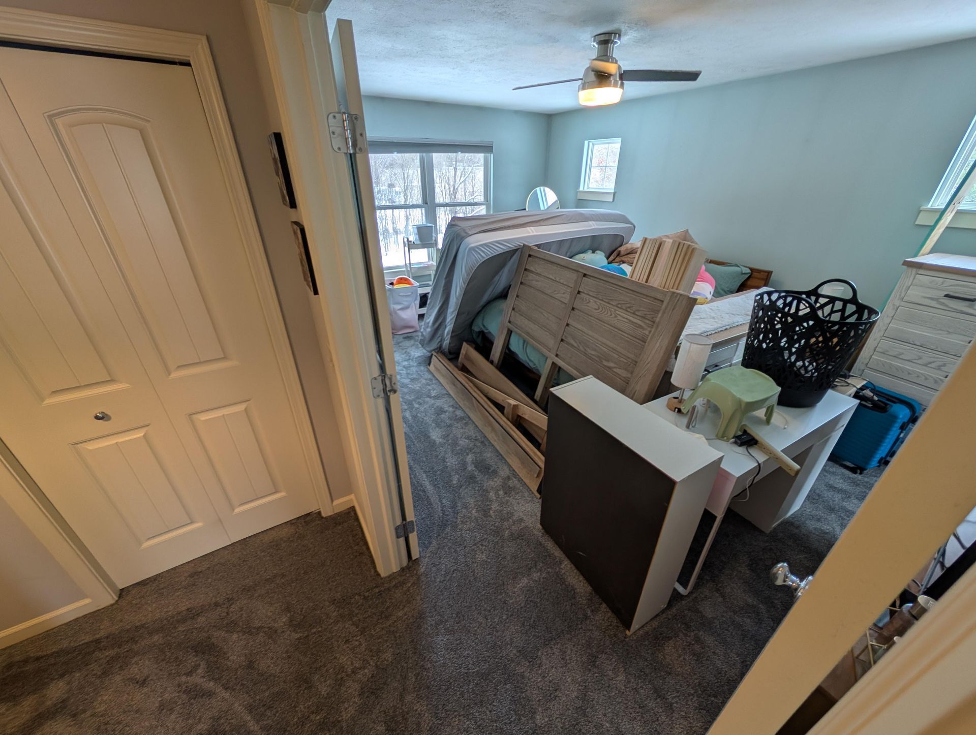 A bedroom filled with lots of furniture and a ceiling fan.